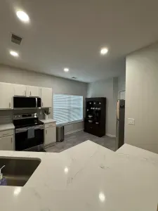 Modern kitchen with quartz peninsula, stainless appliances, bright and airy