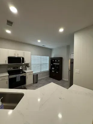 Modern kitchen with quartz peninsula, stainless appliances, bright and airy