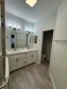 Bright modern bath: double vanity, glass shower, and separate toilet room
