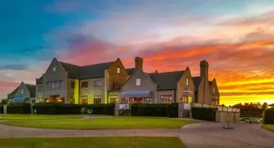 Grand manor retreat with sunset views, sweeping lawns, and private drive.