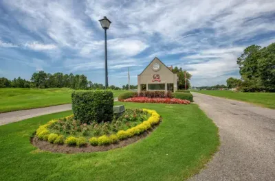 Lush golf community entrance with manicured grounds and welcoming drive.