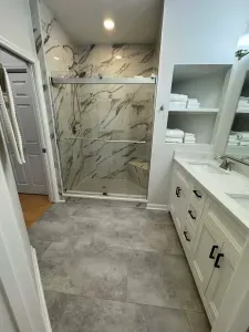 Spa-style bath with marble shower, double vanity, and plush towels
