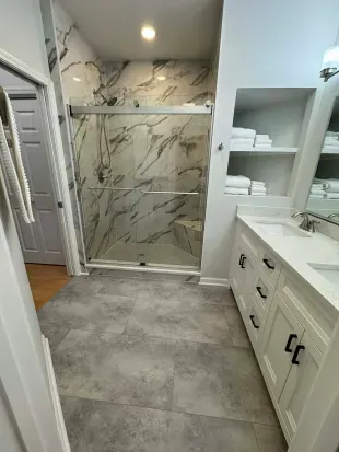 Spa-style bath with marble shower, double vanity, and plush towels