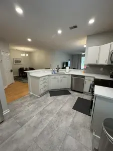 Bright open kitchen with bar seating, stainless appliances, subway tile.