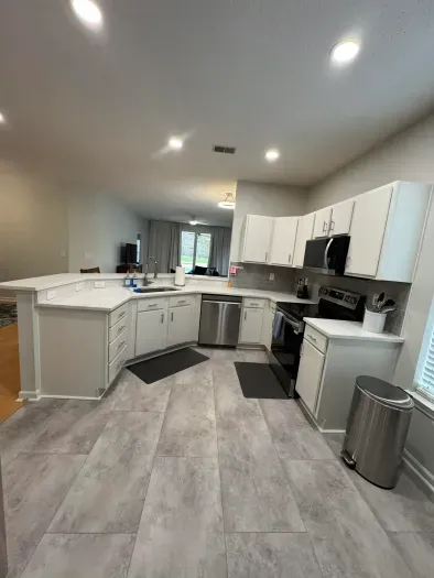 Bright open kitchen with stainless appliances, breakfast bar, and ample prep space