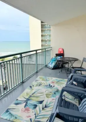 Covered balcony with ocean views, patio seating, and breezy outdoor comfort