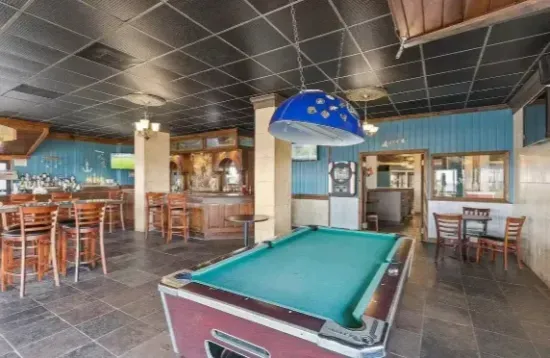 Spacious game room with pool table, bar seating, and casual dining area