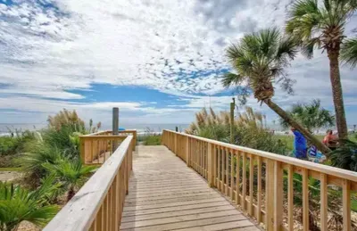 Private boardwalk to the beach with palm-lined coastal views