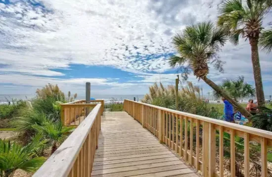 Private boardwalk to the beach with palm-lined coastal views