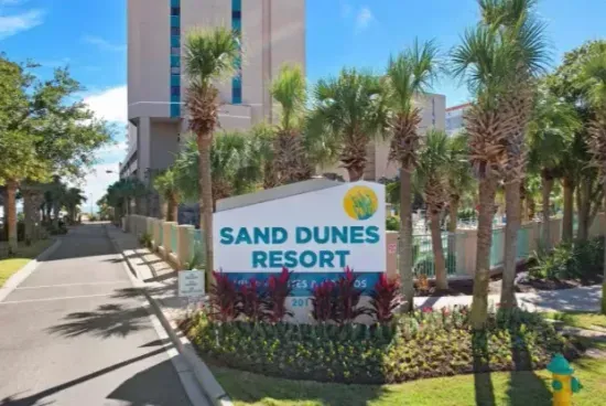 Tropical resort entrance with palm-lined drive and lush landscaping