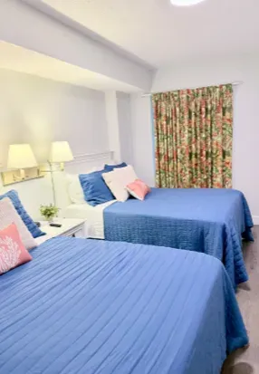 Bright double bedroom with two cozy beds, soft lighting, and cheerful decor