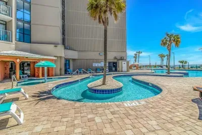 Resort-style pool deck with palm trees and sunny tropical vibes
