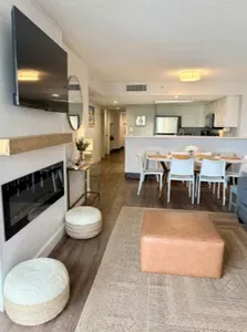 Bright open living space with fireplace, TV, dining area, and breakfast bar