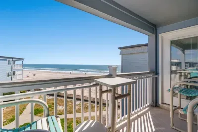 Oceanfront balcony with bar seating—steps to sand and surf.
