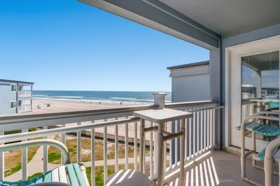 Oceanfront balcony with bar seating—steps to sand and surf.