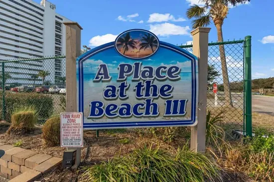 Beachside condo community with palm-lined entry and easy shore access