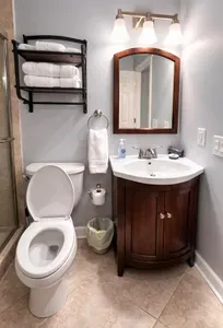 Bright, well-stocked bath with glass shower and stylish vanity.