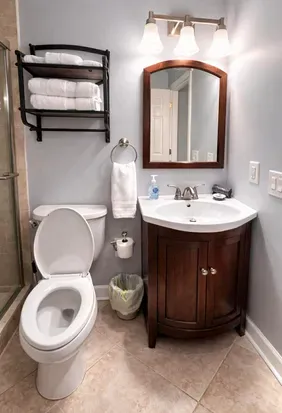 Bright, well-stocked bath with glass shower and stylish vanity.
