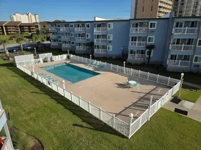 Fenced outdoor pool with loungers—relax at this coastal condo