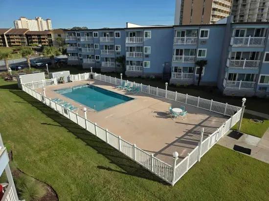 Fenced outdoor pool with loungers—relax at this coastal condo