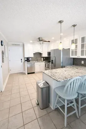 Bright coastal kitchen with granite, stainless & breakfast bar
