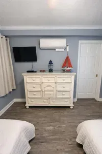 Cozy twin room with TV, AC, and coastal charm—sleep in comfort.