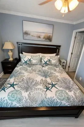 Coastal-chic bedroom with queen bed, ceiling fan, and beachy décor.