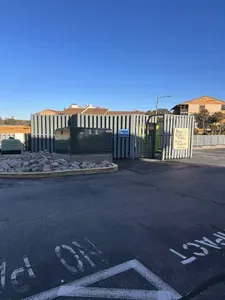 Please take your trash out to the garbage cans behind this fence