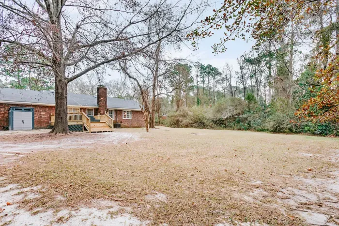 Spacious backyard with open green space and a peaceful setting for relaxing or outdoor play.