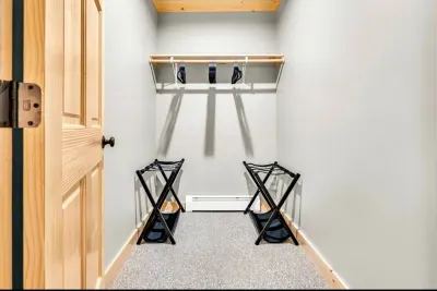 Experience exceptional organization in this spacious master closet. With luggage racks, ample hangers, a storage shelf, and a full-length mirror, it blends style with practicality for a seamless dressing experience that meets all your garment needs.