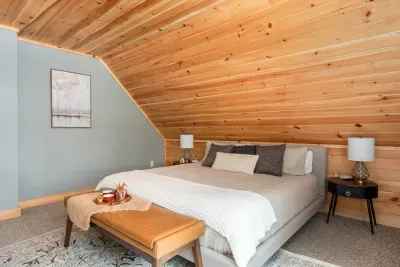 Enter the second master suite, where luxury and comfort converge. A king-size bed with plush quilt and bamboo sheets ensures restful nights, while a leather bench adds elegance. Revel in seasonal lake and mountain views, crafting a serene escape.
