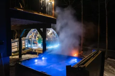 A steamy hot tub overlooks a luxury all-season dome, twinkling with fairy lights.  The perfect spot to unwind and enjoy the serene, illuminated ambiance in any season.