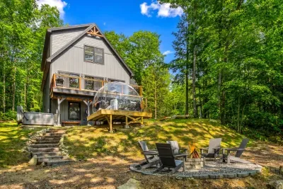 Escape to a backyard oasis featuring an outdoor dome, cozy fire pit, relaxing hot tub, and elevated deck. Enjoy seasonal lake and mountain views in a space perfect for unwinding or gathering. Nature, comfort, and stunning scenery await you!