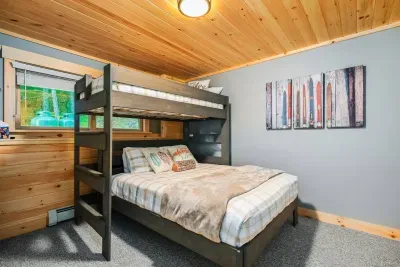 Bedroom number 4, where efficient design meets comfort with a queen bed below and a twin bed perched above. This setup smartly maximizes space, providing versatile sleeping options ideal for diverse needs, whether it's family visits or hosting guests