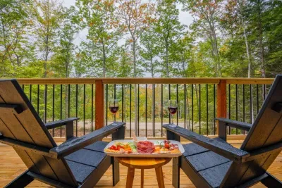 Set on a charming deck, two Adirondack chairs offer a serene escape with seasonal lake and mountain views. Enjoy vibrant seasonal hues, breathtaking sunrises, and peaceful sunsets in this tranquil retreat.