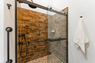 Step into luxury with our rain-head shower and stunning two-tone tile work. The step-free design includes fixed grab bars and a built-in bench for comfort and accessibility at this Poconos group getaway.