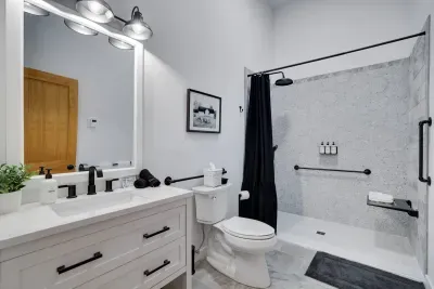 Accessibility meets style in our fully ADA approved bathroom at the Pocono Barndominium. Features include chair-height toilet, multiple grab bars, and a spacious roll-in shower designed for comfort and safety.