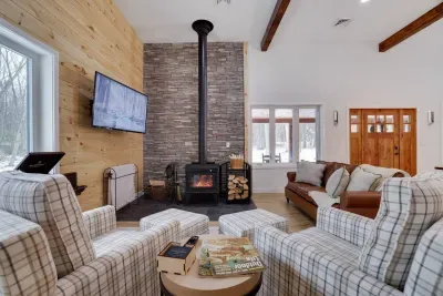 Welcome to the Pocono Barndominium. Our spacious living room with soaring 12-ft ceilings and wood-burning fireplace is where your group will gather for unforgettable moments near Jim Thorpe.