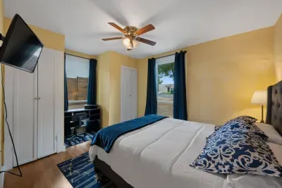 First bedroom with queen sized bed, desk and tv