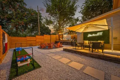 Huge outdoor space with games, shaded lounging area, fire pit, pool loungers, stock tank pool, Weber grill and plenty of tables seating to enjoy BBQ!