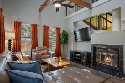 Living room with TV, high ceilings, sky lights and comfortable seating.