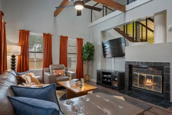 Living room with TV, high ceilings, sky lights and comfortable seating.