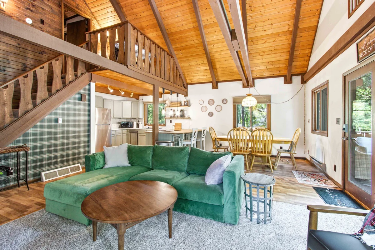 Vaulted living room with green sectional at Chalet on the Fairway Nekoosa, WI