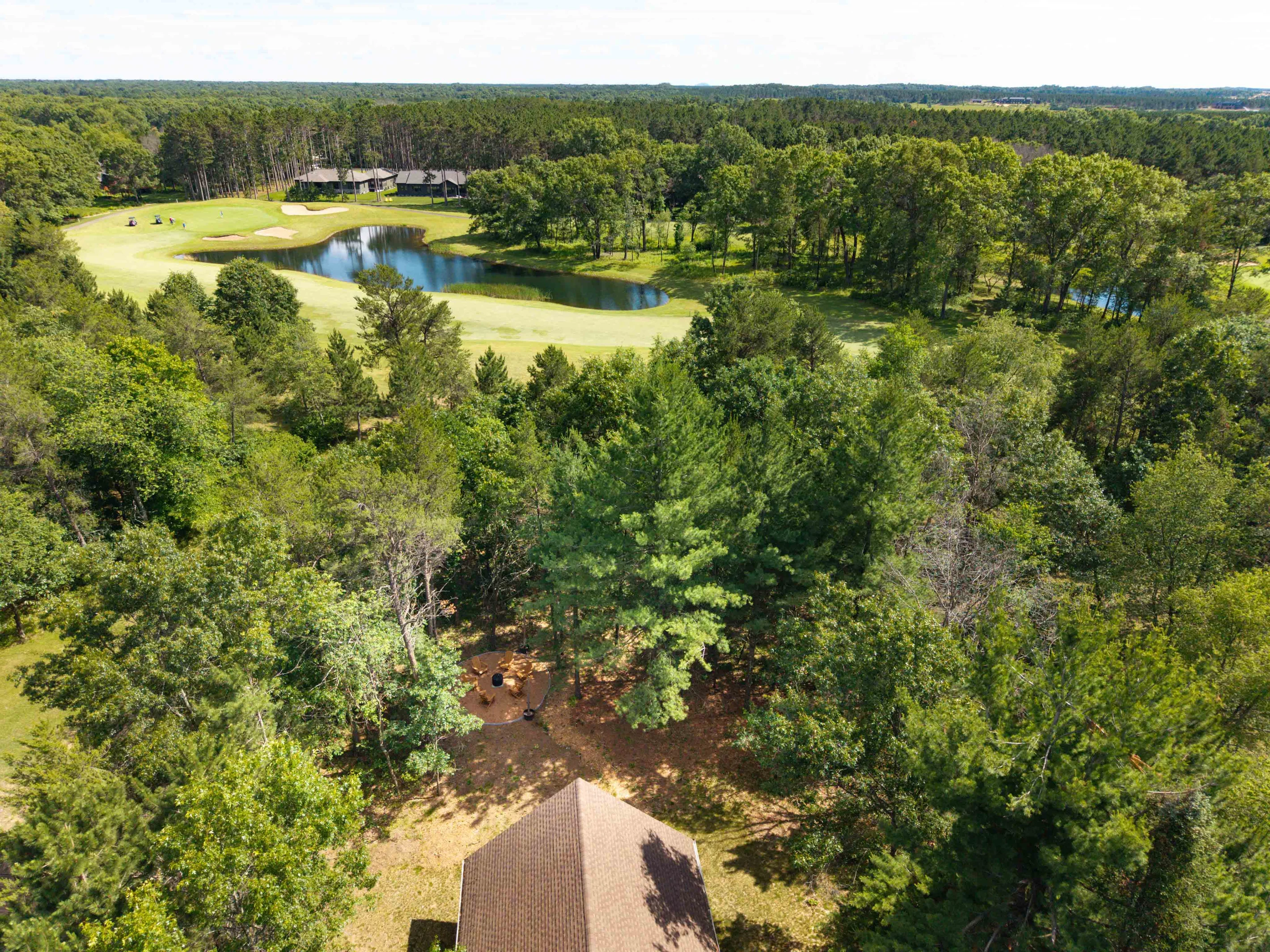 Aerial view of luxury Nekoosa WI cabin on golf course with pine trees and fairway