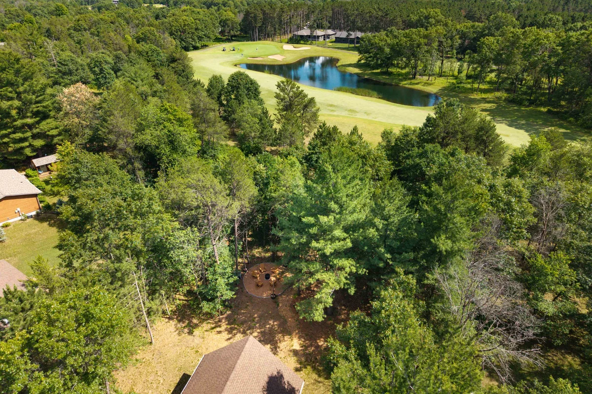 Aerial view of manicured golf course fairway with water hazards and pine forest in Nekoosa, WI
