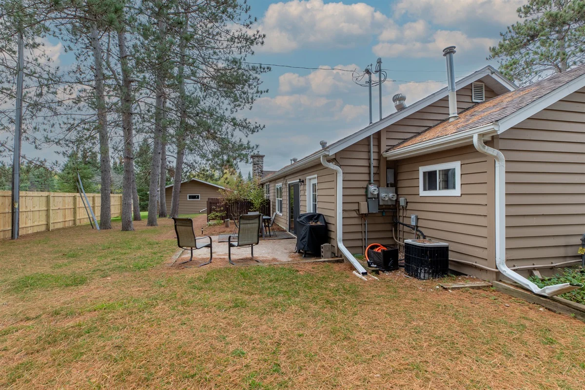 Family-friendly cottage exterior with deck and backyard firepit near Minocqua WI