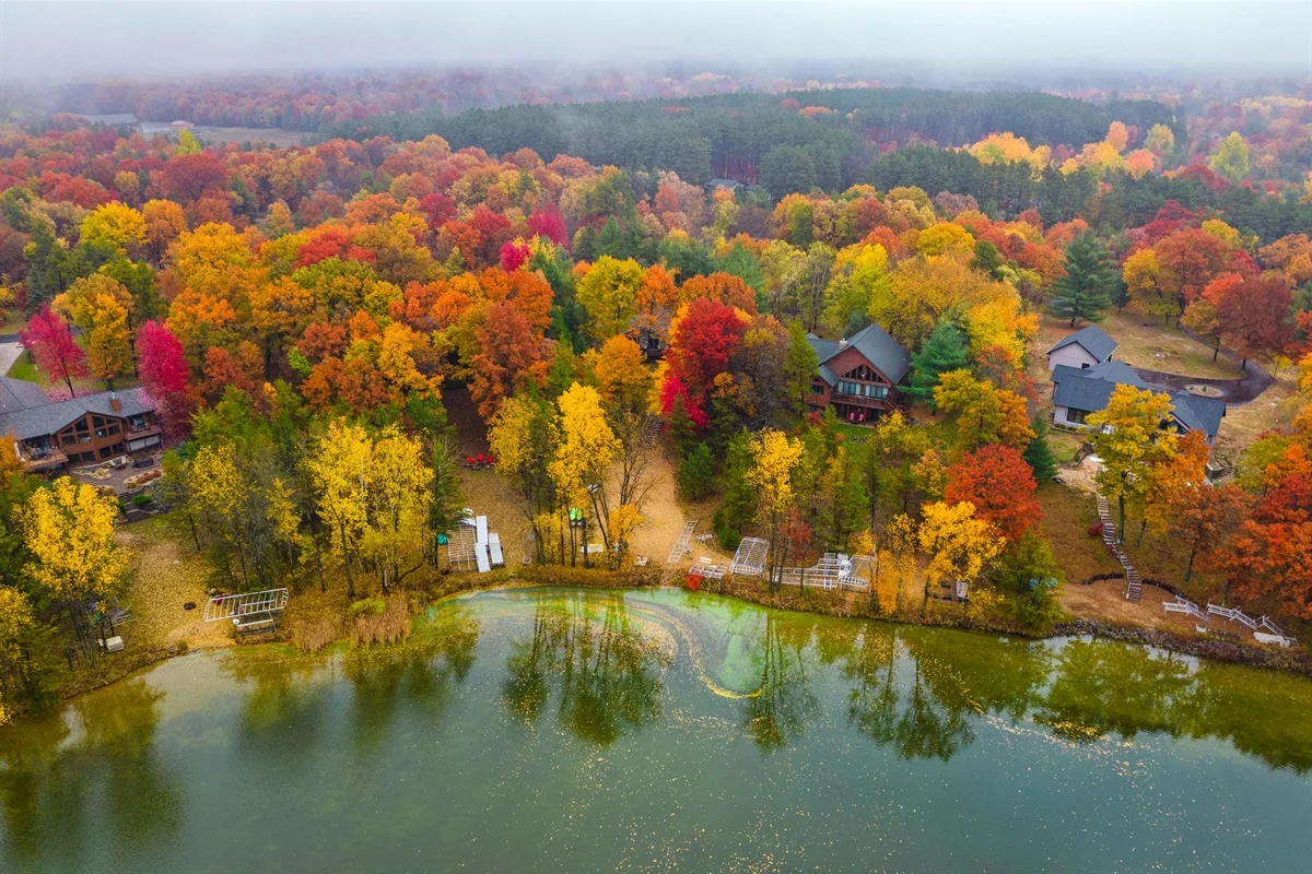 Aerial view of hotel cluster among autumn foliage overlooking lake near Interstate 39 in Plover WI
