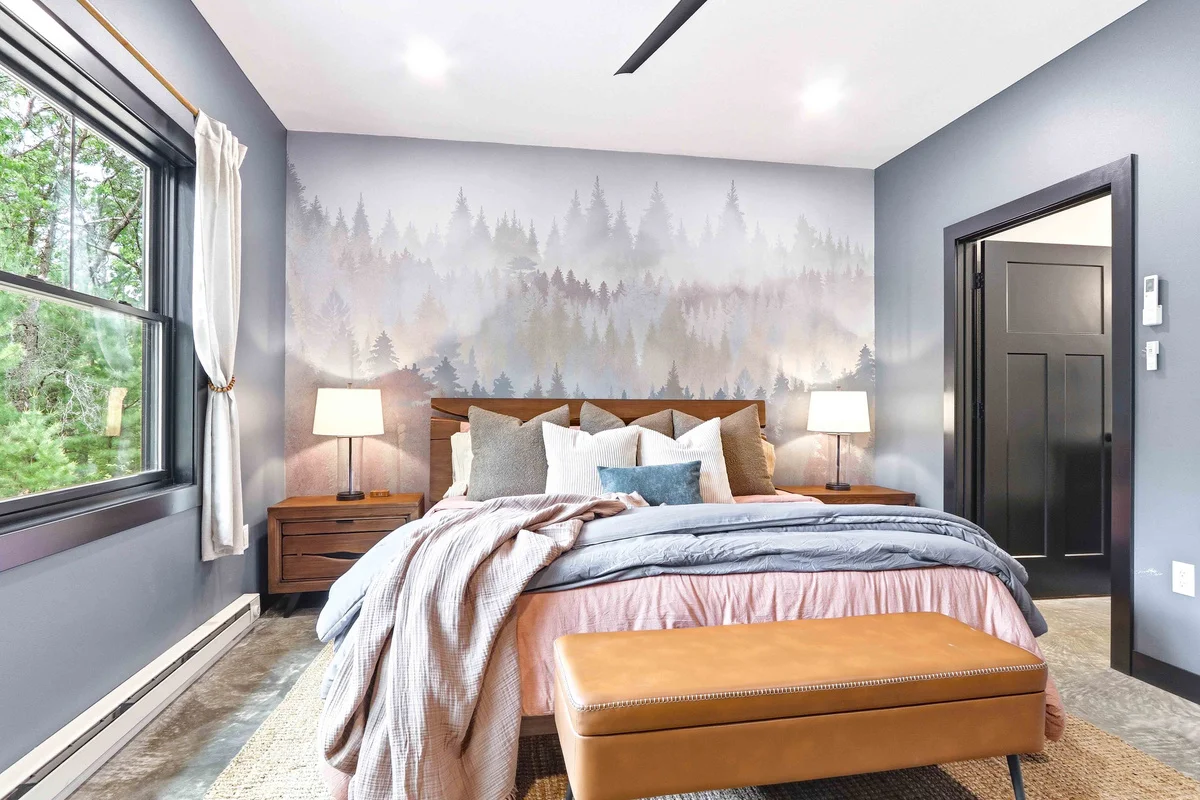 Modern master bedroom with forest mural and white linens ready for STR property turnover in Nekoosa