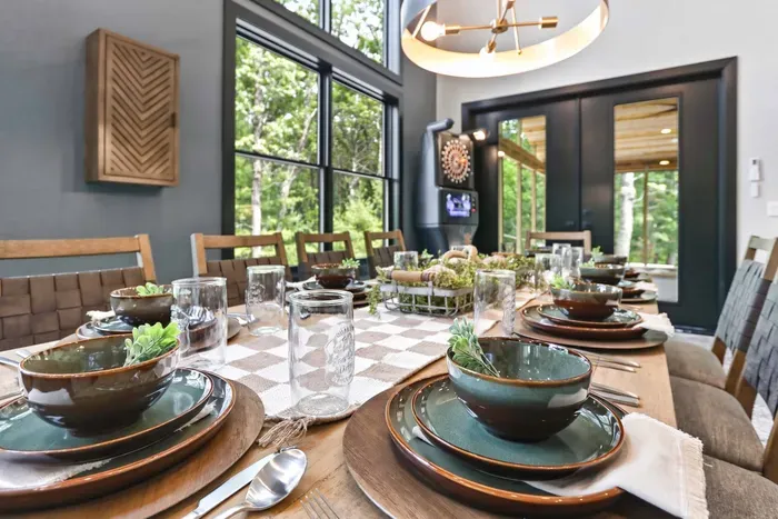 Gather around a beautifully set table where warm textures, treetop views, and a playful game-room backdrop make every meal feel memorable.