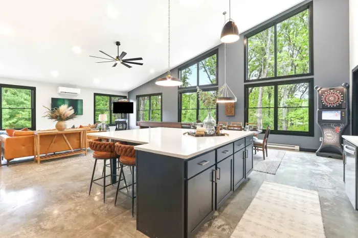 Cook, gather, and play in a sun-filled open living space where soaring windows, a spacious island, and treetop views make every moment feel connected and effortless.